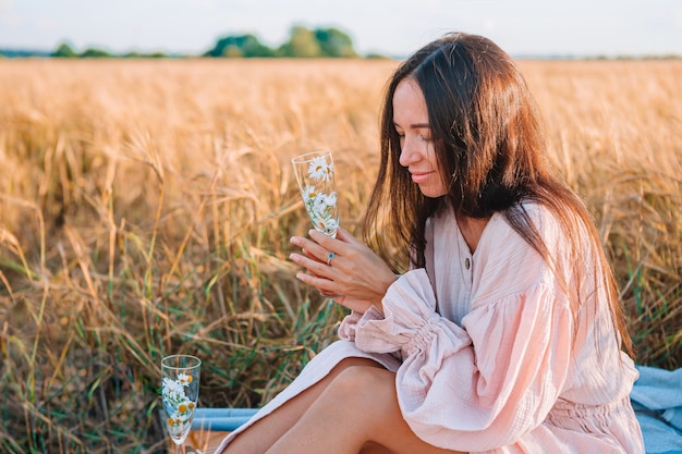 Belle fille dans un champ de blé avec du blé mûr dans les mains