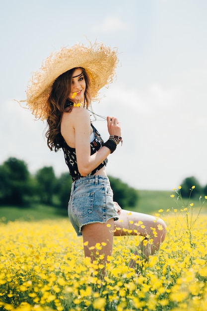 belle fille dans un champ de fleurs jaunes