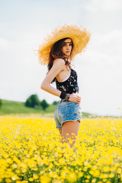 belle fille dans un champ de fleurs jaunes