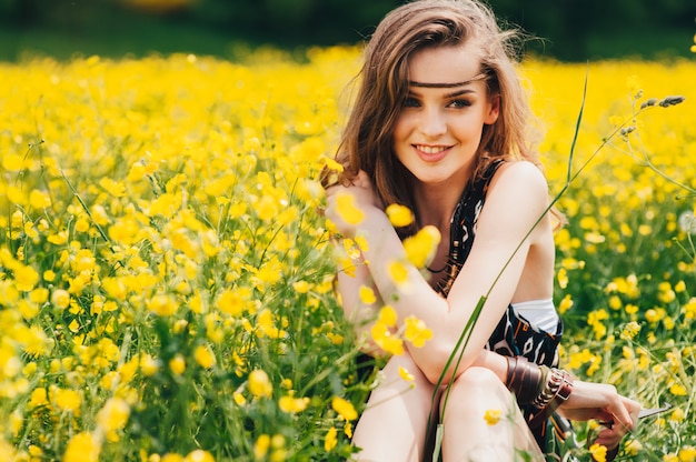 belle fille dans un champ de fleurs jaunes
