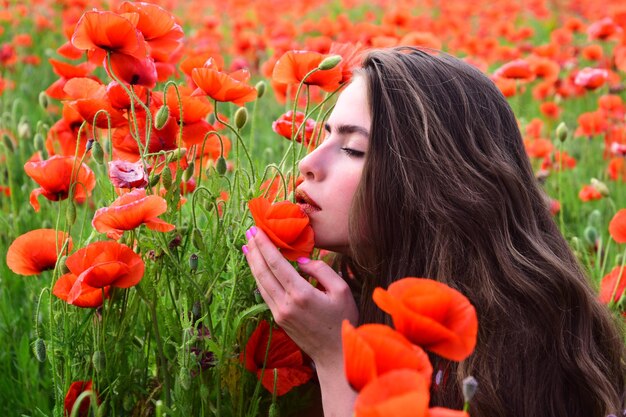 Belle fille dans le champ de pavot rouge