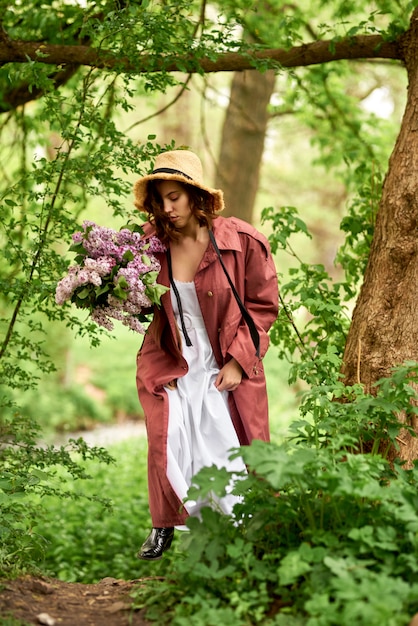 Belle fille dans un chapeau de paille dans la forêt