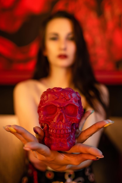 Belle fille dans un corset tient une figure d'un crâne dans ses mains Focus sur le crâne Halloween concept discothèque mascarade