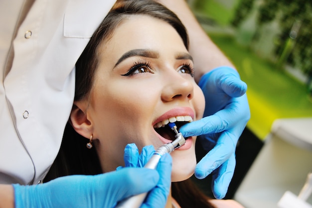 Belle fille dans le fauteuil dentaire à l'examen chez le dentiste