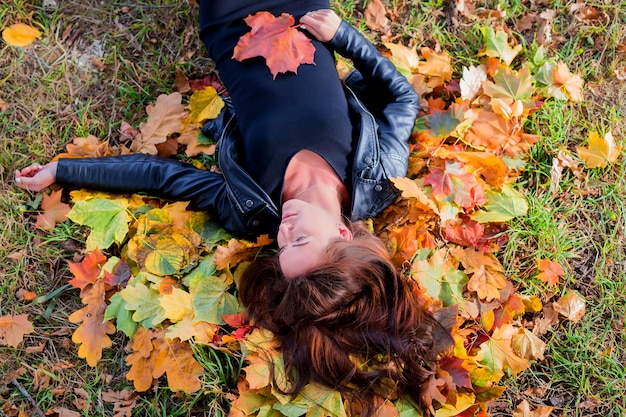 Belle fille dans les feuilles d'automne