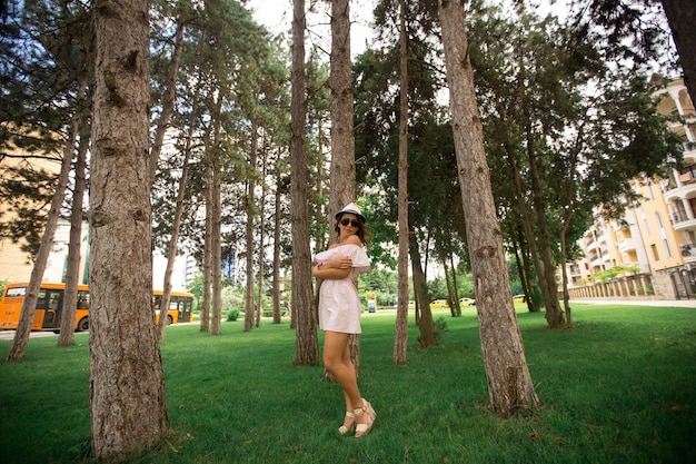 Belle fille dans l'herbe verte du parc et temps ensoleillé