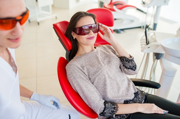 Belle fille dans des lunettes médicales dans un fauteuil dentaire.