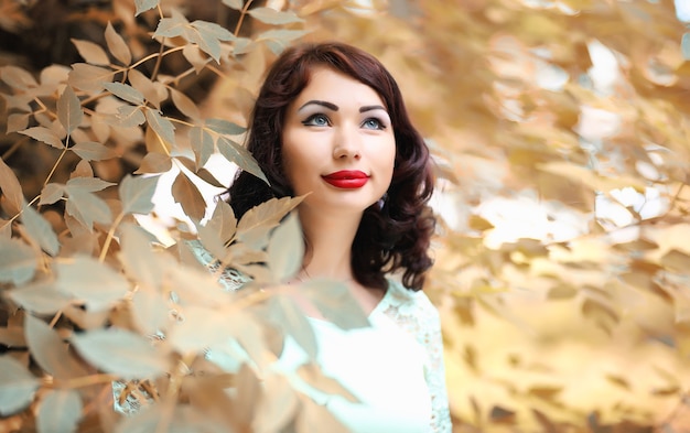 Photo belle fille dans un parc à feuilles caduques d'automne dans l'après-midi