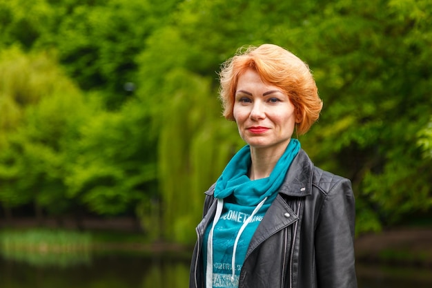 Belle fille dans le parc sur le fond du parc du lac