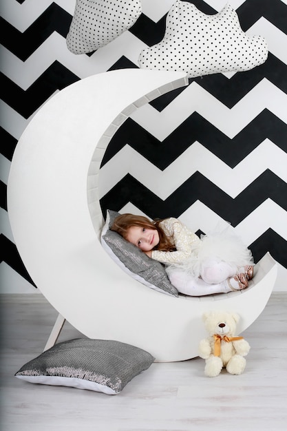 Photo belle fille dans sa chambre avec le décor de la lune et des nuages