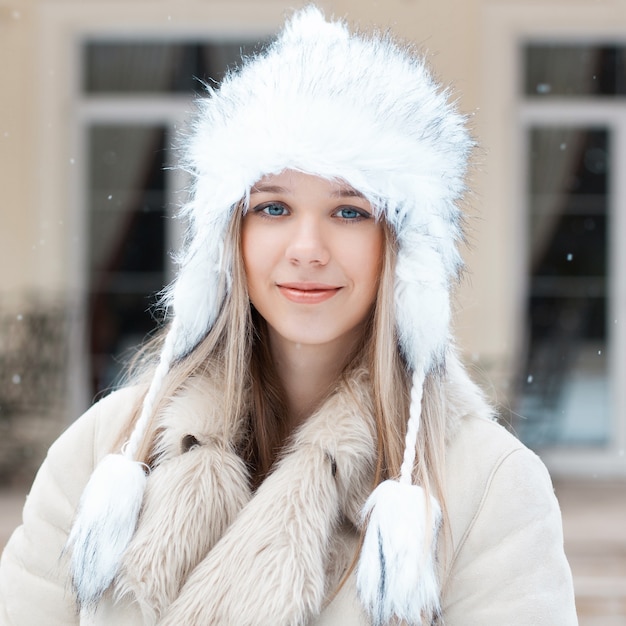 Belle fille dans la veste d'hiver debout près de la maison