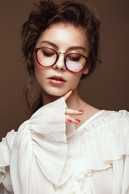 Photo belle fille dans des vêtements élégants avec des lunettes pour la vision. beau visage. photo prise en studio