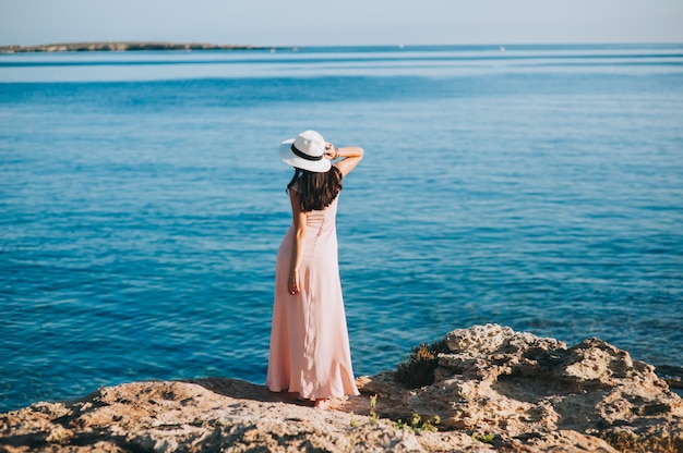 belle fille debout sur le bord de mer affleurement rocheux