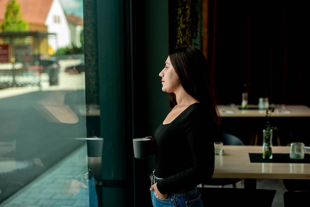 belle fille debout près de la fenêtre