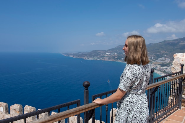 Belle fille debout et profitant de la vue sur la mer en été