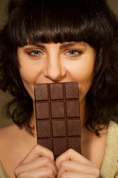 Belle fille avec du chocolat sur fond beige