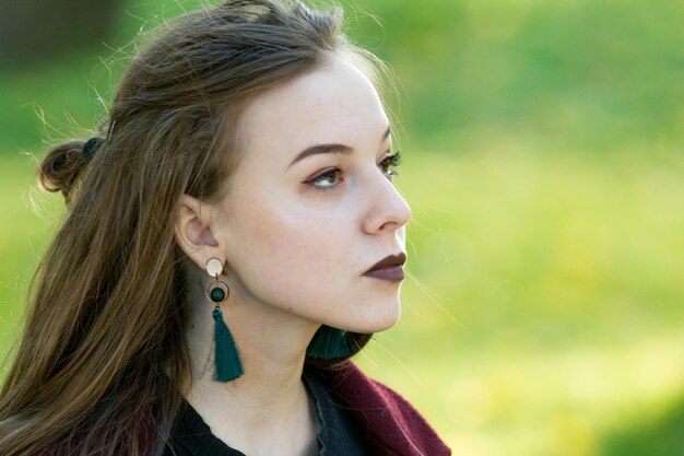 Belle fille avec du rouge à lèvres foncé regardant sur le côté éclairage de contour naturel