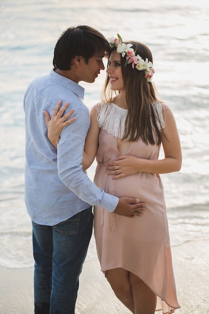 Belle fille enceinte et homme sur la plage