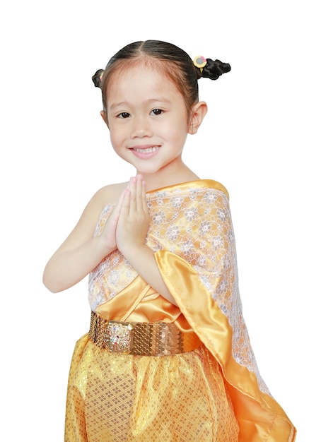 Belle fille enfant asiatique en robe thaïlandaise traditionnelle priant sur fond blanc