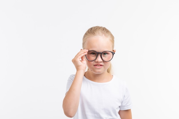 Belle fille enfant portant des lunettes isolées sur blanc.