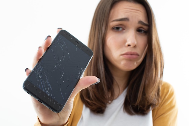 Belle fille est contrariée par le téléphone cassé