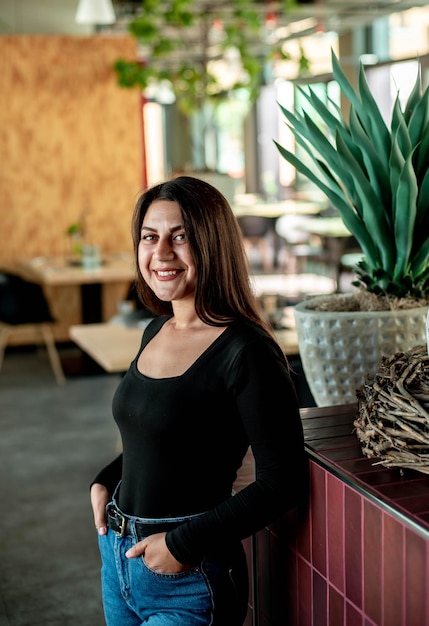 belle fille est debout à l'intérieur et souriant