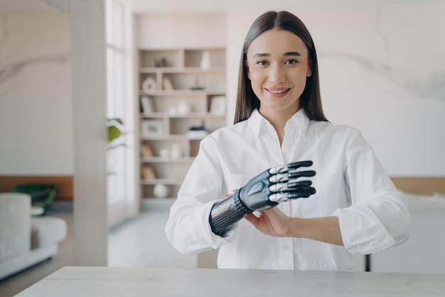 Une belle fille européenne a une main électronique en carbone de haute technologie La technologie moderne pour le bien-être