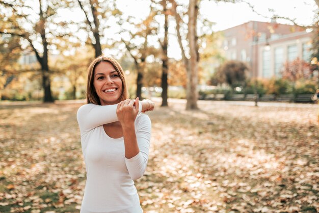 Belle fille exerçant dans un parc en automne.