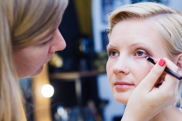 Belle fille faisant du maquillage travail de maquilleuse