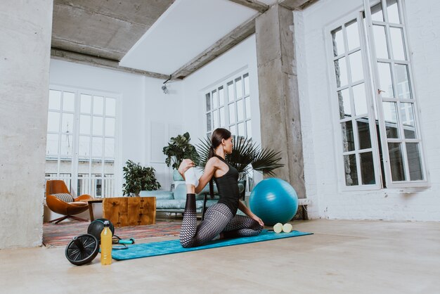 Belle fille faisant de la formation et du yoga à la maison le matin