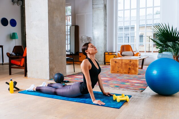 Belle fille faisant de la formation et du yoga à la maison le matin