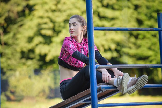 Belle fille fait des exercices de remise en forme dans le parc. Heure d&#39;été