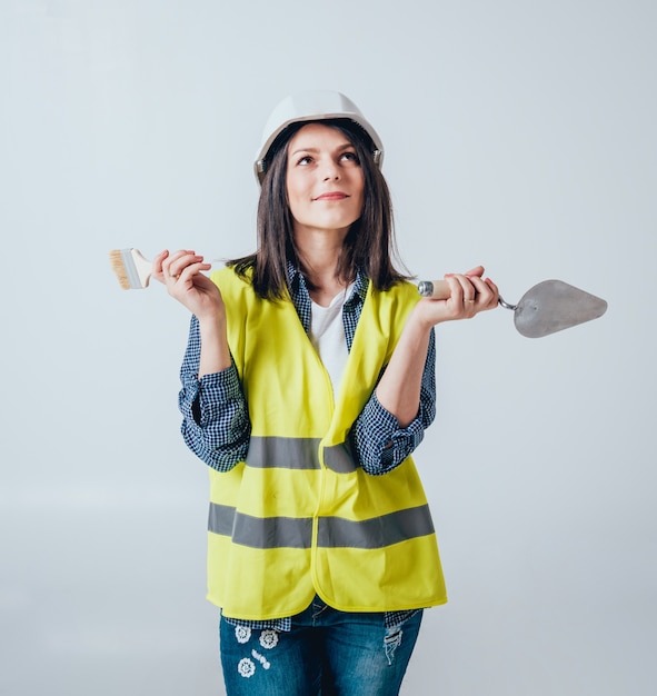 La belle fille fait des réparations dans leur maison.