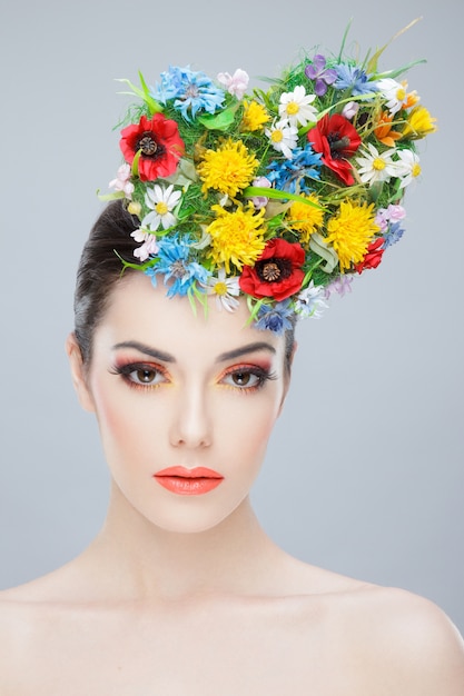 Photo belle fille avec des fleurs colorées de printemps et des épaules nues