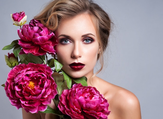 Belle fille avec des fleurs de printemps.