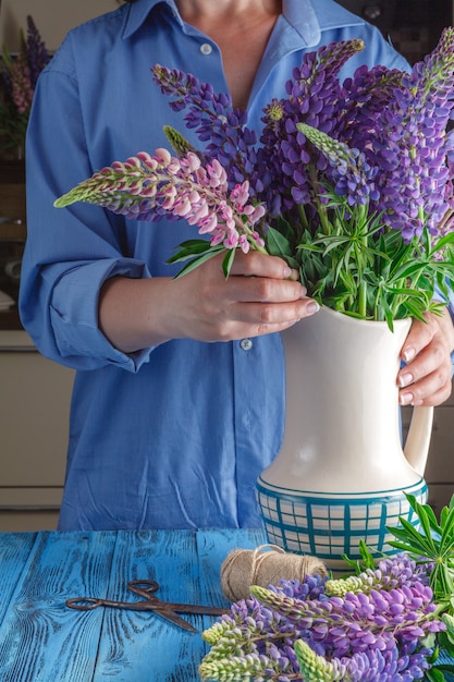 Belle fille avec des fleurs sur la table de la cuisine