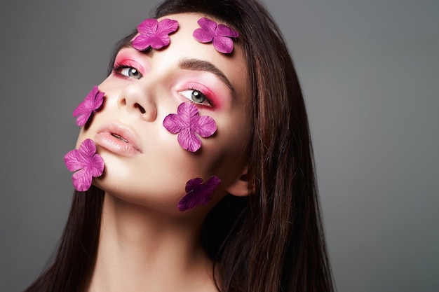 Belle fille avec des fleurs sur le visage