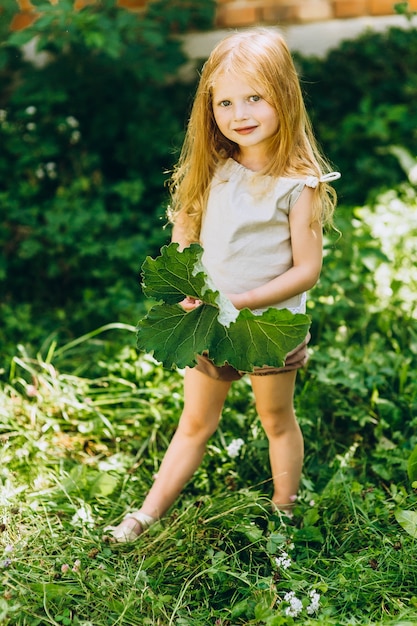 belle fille sur le fond du mur avec une feuille dans ses mains