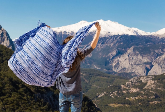 Une belle fille sur le fond des montagnes est recouverte d'une couverture