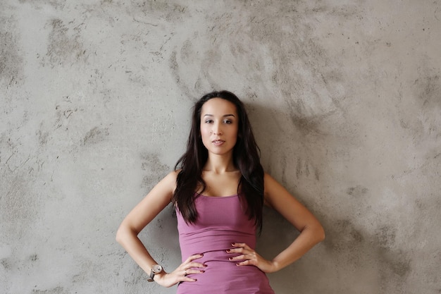 Belle fille sur un fond de mur en béton