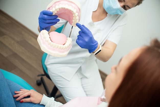 Belle fille gaie dans la chaise du dentiste. Traitement dentaire. Cabinet dentaire