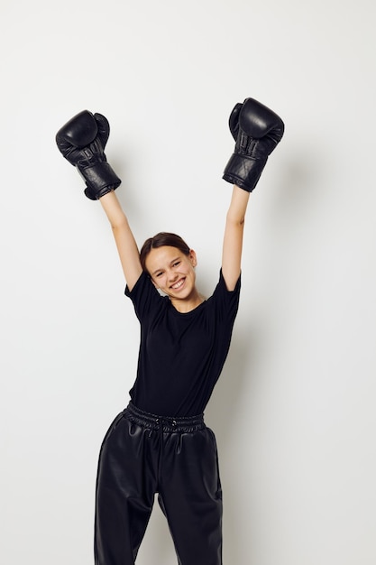 Belle fille en gants de boxe en pantalon noir et un entraînement de fitness tshirt