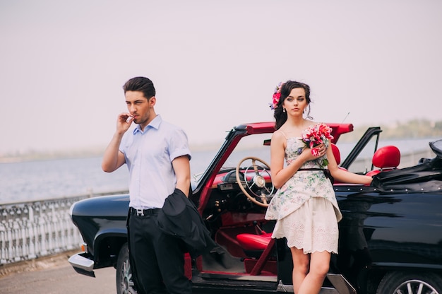 belle fille avec un gars dans une voiture rétro