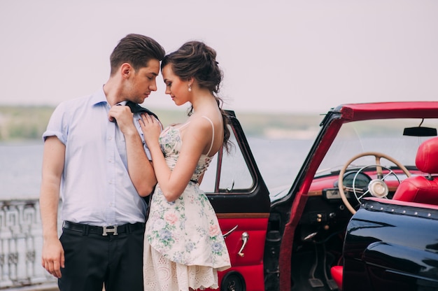 belle fille avec un gars dans une voiture rétro