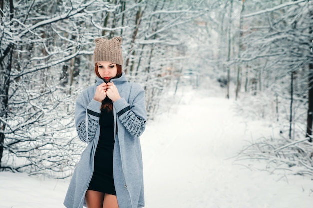 Belle fille gèle en hiver dans la forêt. Photo dans les tons froids