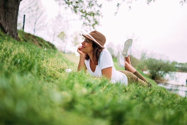 Belle fille sur l&#39;herbe verte portant et profitant de la belle journée.