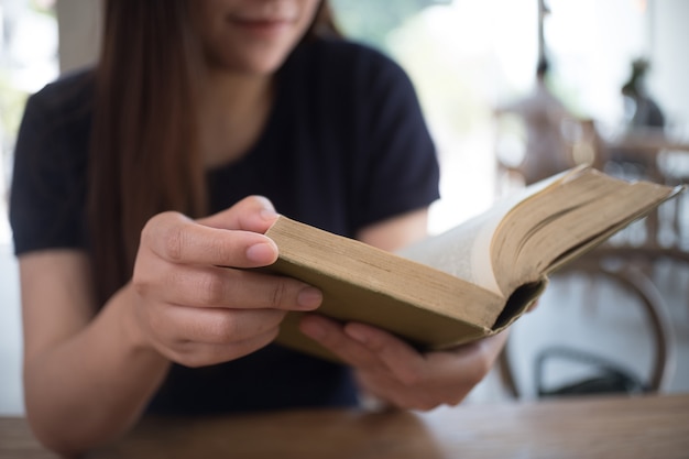 belle fille heureuse de s&#39;asseoir en lisant un livre