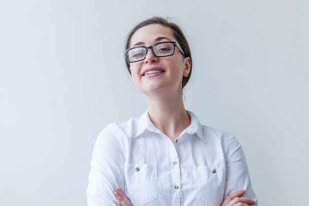 Belle fille heureuse souriante. Portrait de jeune femme à lunettes isolé sur fond blanc. Émotion humaine positive expression faciale langage corporel.