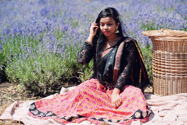 Belle fille indienne porte une robe traditionnelle saree inde dans un champ de lavande violette