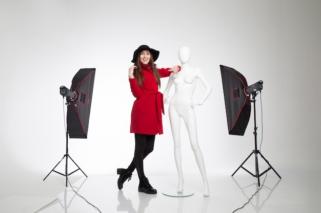 Belle fille intéressante dans le chapeau à côté du mannequin femme blanche posant en studio sur fond blanc